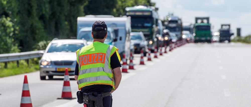 .Ein Polizist kontrolliert auf der Autobahn.