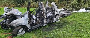 Das ausgebrannte Wrack des Autos steht bei Brunsbüttel am Fahrbahnrand.