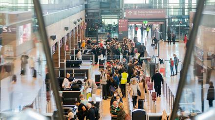 Zahlreiche Passagiere stehen am Hauptstadtflughafen Berlin Brandenburg «Willy Brandt» (BER) im Terminal 1 vor der Sicherheitskontrolle Schlange. 