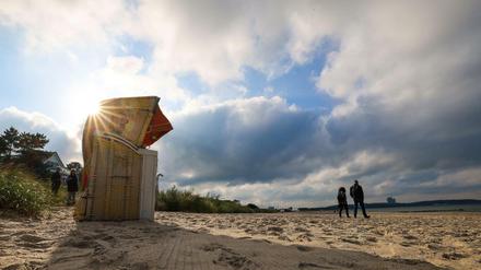 Menschen spazieren am Ostseestrand von Niendorf.