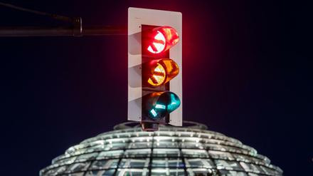 Eine Ampel vor der Kuppel des Reichstagsgebäudes.