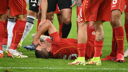 Nordmazedoniens Arijan Ademi liegt verletzt auf dem Boden.
