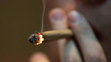 Ein Mann raucht im Coffee Shop einen Joint mit Marihuana. Die Sondierungen zur Ampel-Koalition könnten auch in Deutschland eine Entkrimininalisierung bewirken.