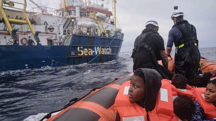 Ein Rettungsboot bringt gerettete Menschen zur Sea-Watch 3.