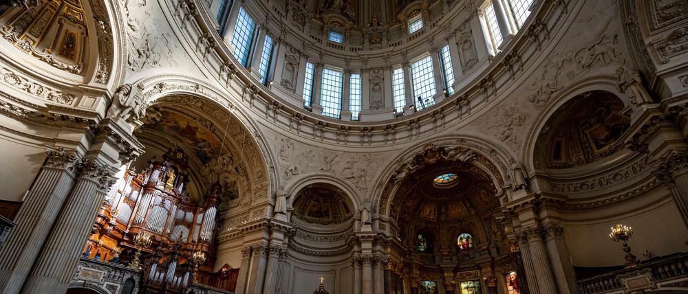Besucher sitzen mit Maske im Berliner Dom