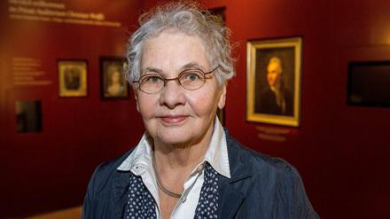 Porträtbild von Christiane Nüsslein-Volhard, die in einem Ausstellungsraum steht.
