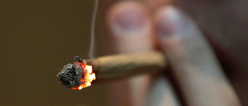 Ein Mann raucht einen Joint.