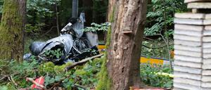 Trümmerteile eines Hubschraubers vom Typ Robinson R44 und Feuerlöscher liegen in einem Wald nahe der Grenze zu Hessen und Bayern. 