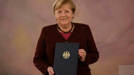 Angela Merkel mit ihrer Entlassungsurkunde. 