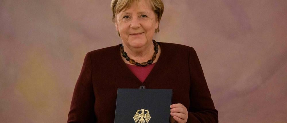 Angela Merkel mit ihrer Entlassungsurkunde.