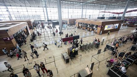 Reisende stehen am Terminal 1 des Flughafen BER. (Symbolbild)