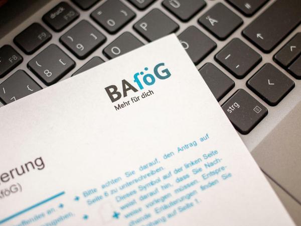 Ein Bafögantrag liegt auf der Tastatur eines Laptops.