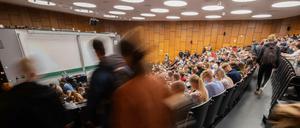 Studierende sitzen in einem Hörsaal, andere suchen noch einen Platz.