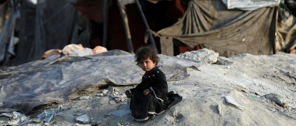 Ein mit ihrer Familie vertriebenes Mädchen sitzt außerhalb einer provisorischen Unterkunft in Kabul.