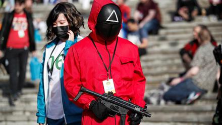 Ein Mann trägt bei der Comic Con in London ein Squid-Game-Kostüm. 