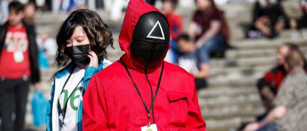 Ein Mann trägt bei der Comic Con in London ein Squid-Game-Kostüm.