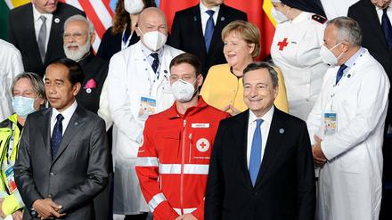 Kanzlerin Angela Merkel zwischen zwei Ärzten auf einem Foto beim G20-Gipfel.