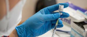 Die Mitarbeiterin eines mobilen Impfteams zieht in einem Alten- und Pflegeheim den Impfstoff von Biontech/Pfizer in eine Spritze auf.