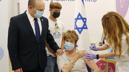 Israels Premier Naftali Bennett begleitet seine Mutter Myrna Bennett bei der Auffrischungsimpfung.