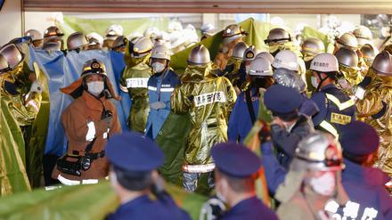 Feuerwehrleute versammeln sich am Bahnhof Kokuryo in Tokio, nachdem in einem Zug der Keio-Linie ein Feuer ausgebrochen war.