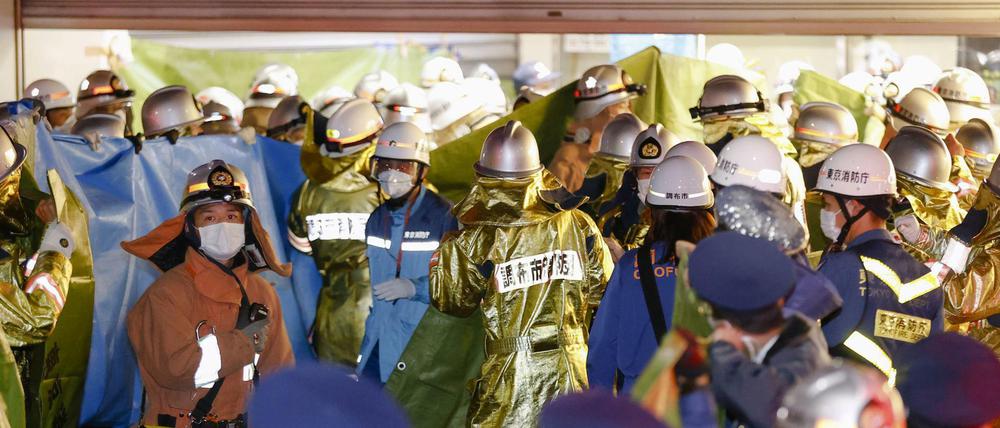 Feuerwehrleute versammeln sich am Bahnhof Kokuryo in Tokio, nachdem in einem Zug der Keio-Linie ein Feuer ausgebrochen war.