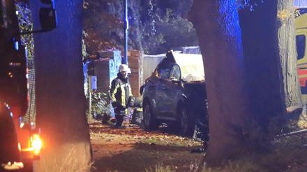 Ein Feuerwehrmann steht an dem in den Unfall verwickelten SUV.