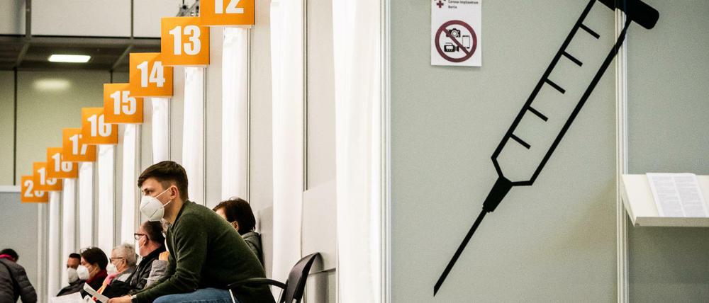 Menschen warten in einem Corona-Impfzentrum auf ihre Impfung.
