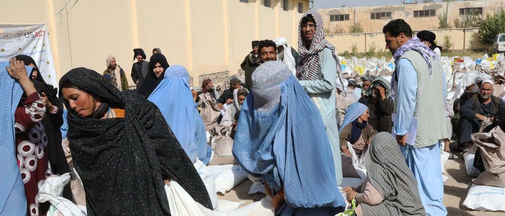 Frauen verlassen eine Verteilungsstelle des Welternährungsprogramm WFP am Stadtrand mit Lebensmittelrationen