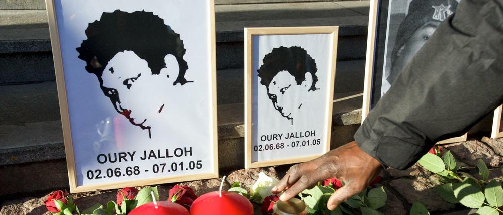 Rosen liegen vor dem Bild von Oury Jalloh am 07.01.2014 am Hauptbahnhof in Dessau-Roßlau (Sachsen-Anhalt).