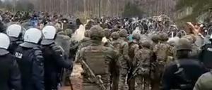 Polnische Polizisten halten Migranten an der Grenze zu Belarus auf.
