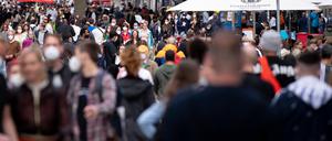 Zahlreiche Menschen spazieren durch die Fußgängerzone in der Innenstadt.