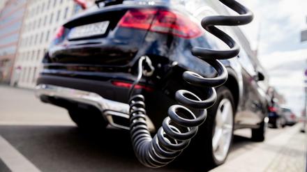 Ein Auto mit Plug-in-Hybrid-Antrieb lädt an einer Ladesäule.