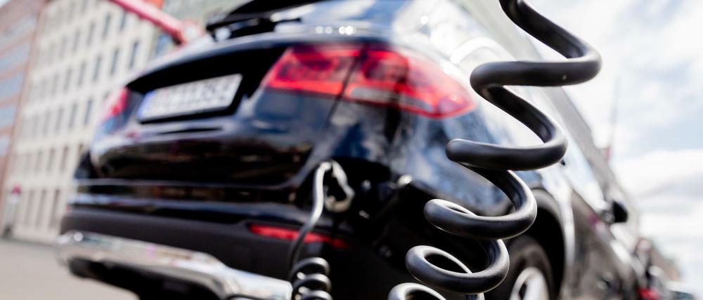 Ein Auto mit Plug-in-Hybrid-Antrieb lädt an einer Ladesäule.