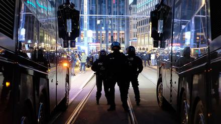 Polizisten stehen bei einer Kundgebung von Kritikern der Coronamaßnahmen der Bundesregierung auf dem Augustusplatz zwischen Wasserwerfern.