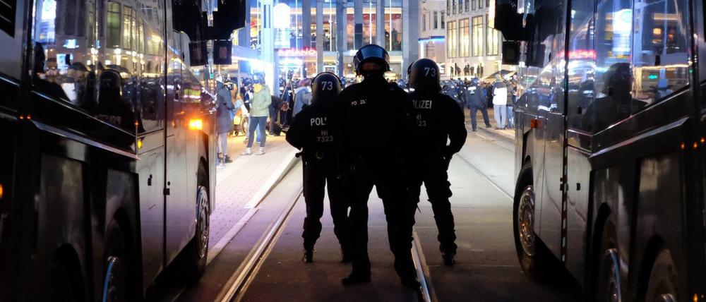 Polizisten stehen bei einer Kundgebung von Kritikern der Coronamaßnahmen der Bundesregierung auf dem Augustusplatz zwischen Wasserwerfern.