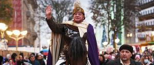 Ein Darsteller des St. Martin reitet auf einem Pferd durch die Duisburger Innenstadt.