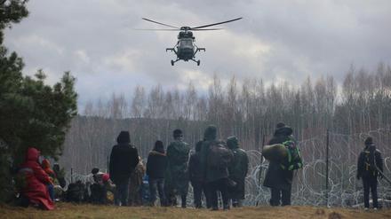 Konfrontation von Humanität und Realität. Tausende Migranten warten in Belarus darauf, die EU-Außengrenze in Polen zu überwinden. Ein polnischer Militärhubschrauber observiert die Szenerie.