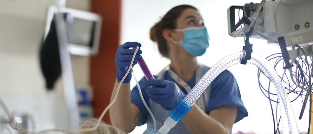 Eine Patientin auf der Intensivstation wird von Krankenschwester Steffi medizinisch versorgt.