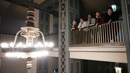 Das E-Sports-Team Eintracht Spandau auf einer Balustrade, im Vordergrund ein Kronleuchter.