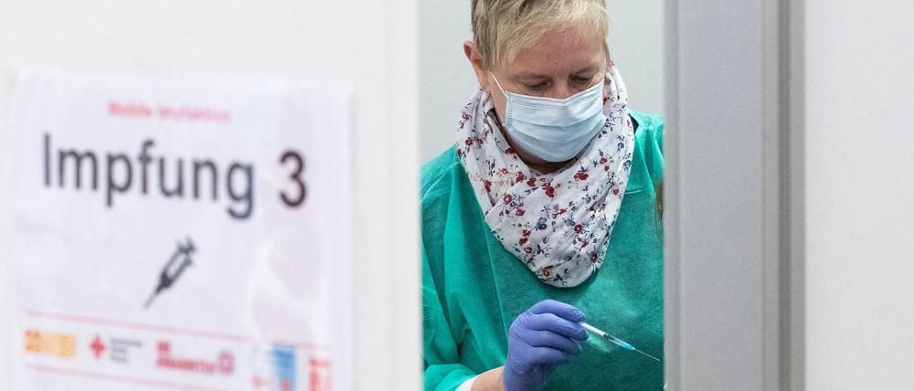 Auffrischimpfungen (Booster) gegen das Coronavirus: Arzthelferin Beate Bug hält eine Spritze bereit zur Impfung in einem Impfzelt.