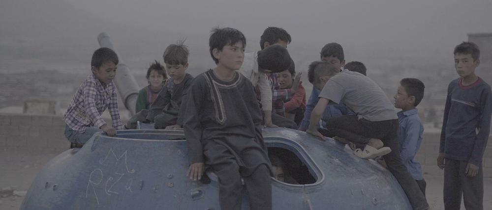 Kinder in Afghanistan spielen auf einem alten Panzer.