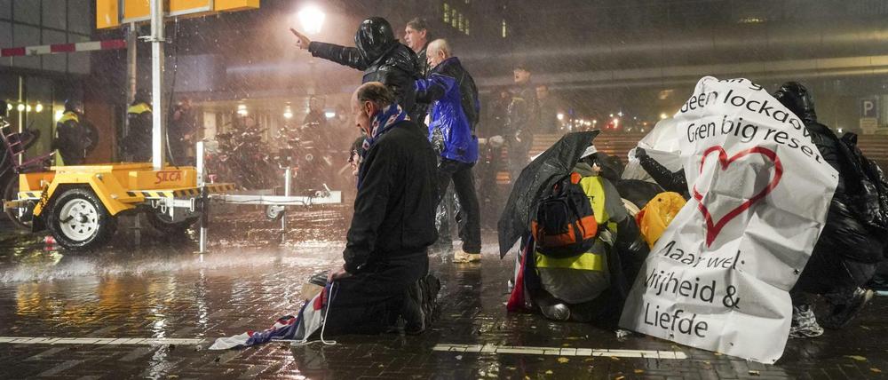 Menschen protestieren am Hauptbahnhof Den Haag gegen den Teil-Lockdown.