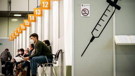 Menschen warten im Corona-Impfzentrum auf dem Messegelände auf ihre Impfung.
