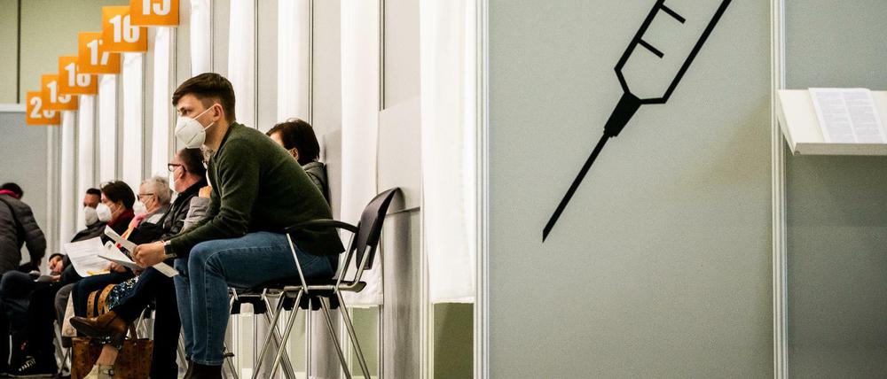 Menschen warten im Corona-Impfzentrum auf dem Messegelände auf ihre Impfung.