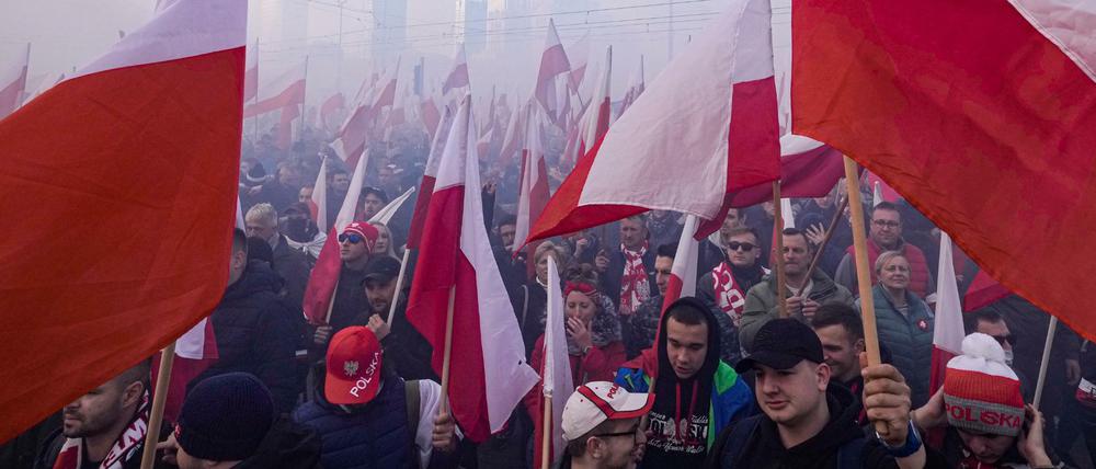 Mitglieder rechtsextremer Gruppen mit Fackeln und polnischen Flaggen beim Marsch zum Unabhängigkeitstag in Polen.