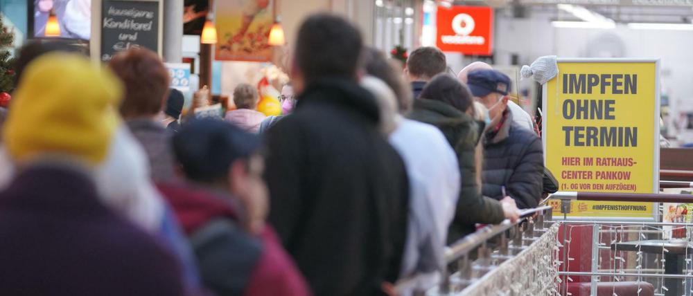 Zahlreiche Menschen stehen wartend in einer Schlange vor einem Impfzentrum in einem Einkaufscenter in Berlin.
