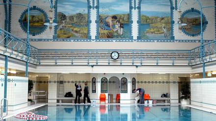 Alte Halle des Stadtbads Charlottenburg, Schwimmbecken vor buntem Wandbild.