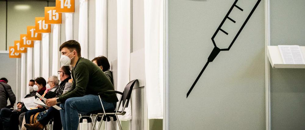 Menschen warten im Corona-Impfzentrum auf dem Messegelände auf ihre Impfung. 