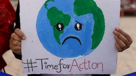 Ein Klimaaktivist hält ein Plakat während eines Protestes