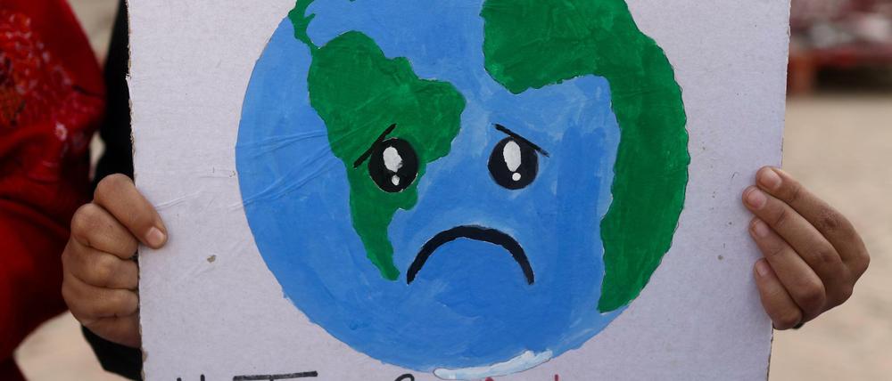 Ein Klimaaktivist hält ein Plakat während eines Protestes